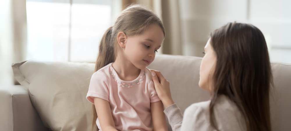 Kind wird von Elternteil getröstet